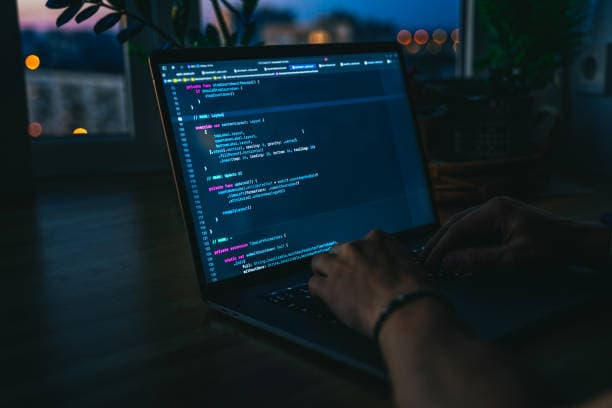 Developer writing code on a laptop at night, representing custom bot development